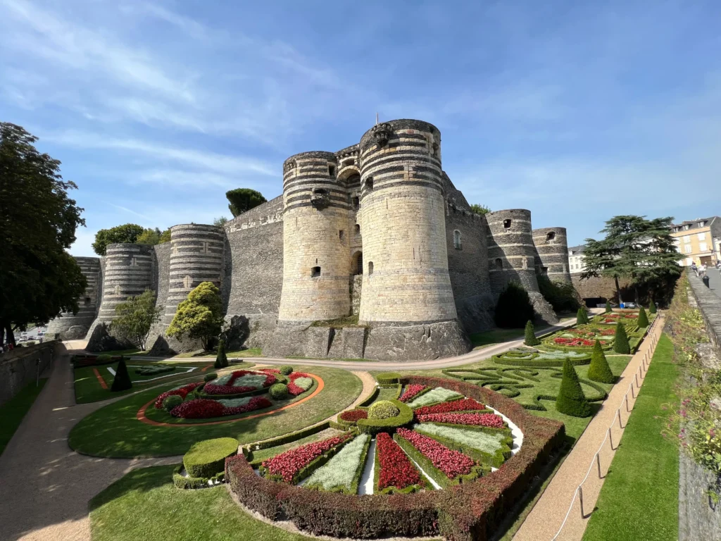 Castillo de Angers y vista al cuidado jardin, recortado haciendo dibujos geométricos y jugando con los colores 